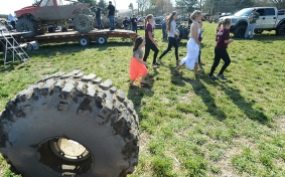 Baylee Hart makes her way through the mud hop pits after getting dressed for her senior prom with an entourage of younger girls in tow.