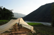 A woman walks out of a tent nestled in a scenic spot on Sunday May 03, 2015 in the Nuwakot District of Nepal. A deadly earthquake in Nepal killed thousands. Tent encampments are a common sight as people have lost their homes or are afraid to return to them because of earthquake damage.