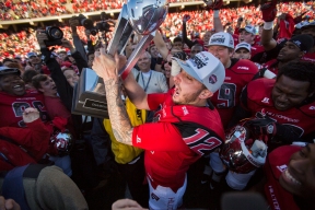 Western Kentucky quarterback Brandon Doughty (12) is raises the Conference USA trophy after beating Southern Mississippi in the Conference USA football Championship game between WKU and Southern Mississippi University on Saturday Dec. 5 at L. T. Smith Stadium in Bowling Green, Ky.