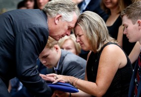 Gov. Terry McAuliffe hands Karen Cullen, the widow of Lt. H. Jay Cullen, the flag during his funeral service Saturday, August 19, 2017, at Southside Church of the Nazarene. Their sons Max Cullen, left, and Ryan Cullen, right, sit with her. Cullen was one of two State Troopers who were killed in a helicopter crash last weekend during the white supremacist rally in Charlottesville.