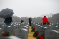 3rd Place Feature: Kristen Zeis, Virginian-Pilot--- Chief Petty Officer Franklin Cheromiah watches over as volunteers and loved ones place over 9,000 live wreaths at grave sites as part of the Horton Wreath Society wreath laying event at Albert G. Horton Jr. Memorial Veterans Cemetery in Suffolk, Va., on Saturday, December 15, 2018. This was the 11th year the society put on the event.